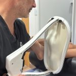 El Dr. Alberto Martínez explorando el pie de un paciente en camilla durante un estudio biomecánico de la pisada