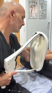 El Dr. Alberto Martínez explorando el pie de un paciente en camilla durante un estudio biomecánico de la pisada